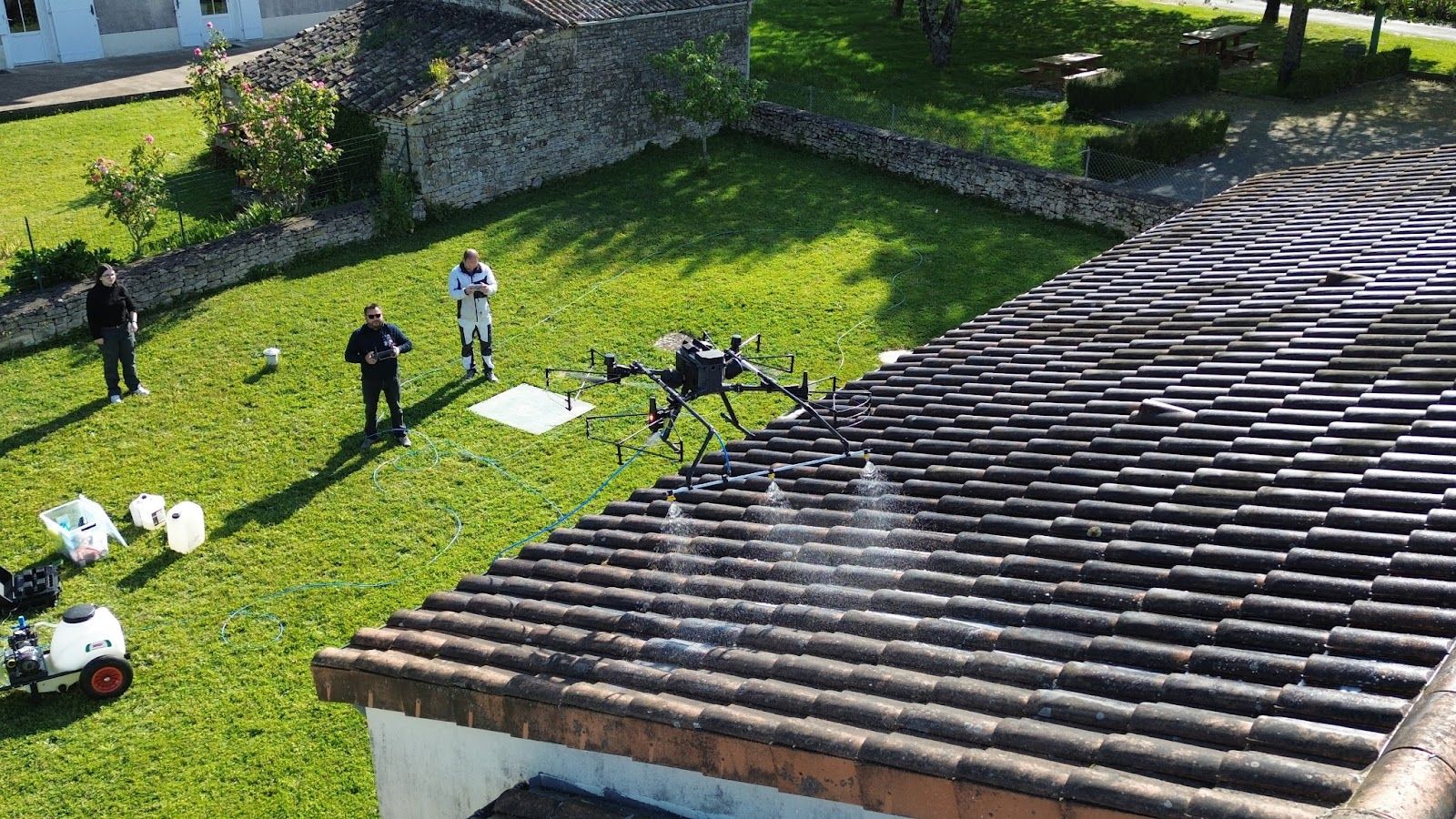 Chantier de traitement de toiture par drone dans un jardin